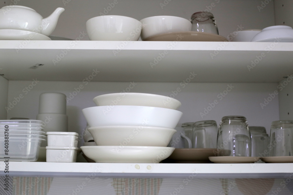 Clean dishes and tableware on a white shelf Clean dishes and tableware on a white shelf