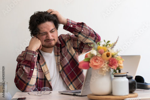 Man making homework and getting confuse in the living room front his laptop