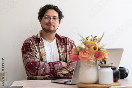 Young man with glasses from his laptop making gesture and wellness vibes concept in the living room
