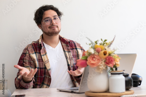 Young man with glasses from his laptop making gesture and wellness vibes concept in the living room