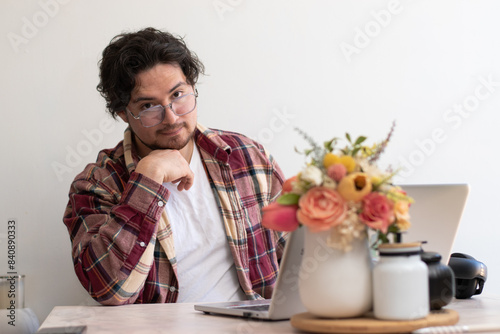 Young man with glasses from his laptop making gesture and wellness vibes concept in the living room