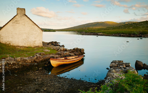 Obraz na płótnie Old wooden fishing boat in lake by Fisherman's hut with mountains in background at Connemara, Galway, Ireland w salonie