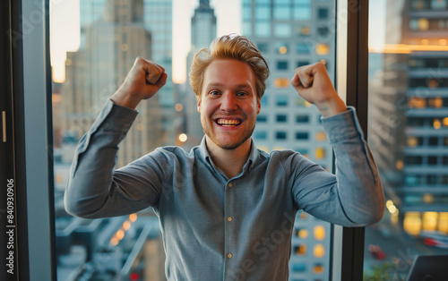 A man is smiling and raising his hands in the air