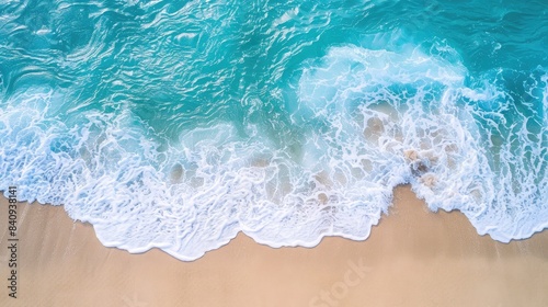 Aerial view of a pristine beach with turquoise waves gently lapping against the shore