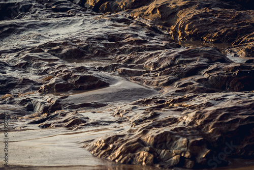 A large rocks surrounded by waves of the ocean