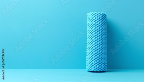 single foam roller in the lowerleft third on a plain light blue background photo