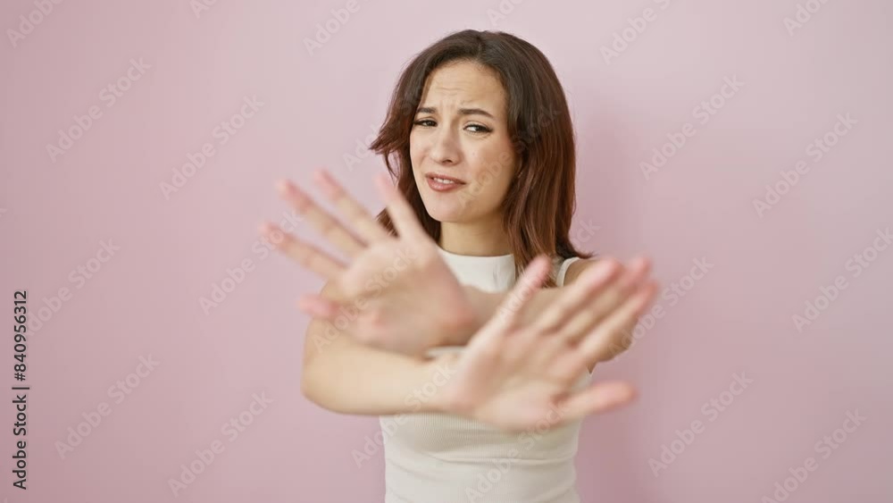 Fighting frustration, young, beautiful hispanic woman in sleeveless pink t shirt standing with hands in a stop gesture over isolated background, expressing anger and annoyance. Fighting frustration, young, beautiful hispanic woman in sleeveless pink t shirt standing with hands in a stop gesture over isolated background, expressing anger and annoyance.