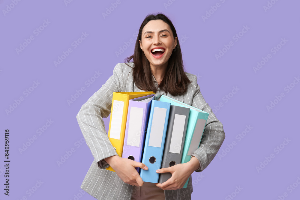 © Pixel-Shot - Happy young businesswoman with folders on lilac background