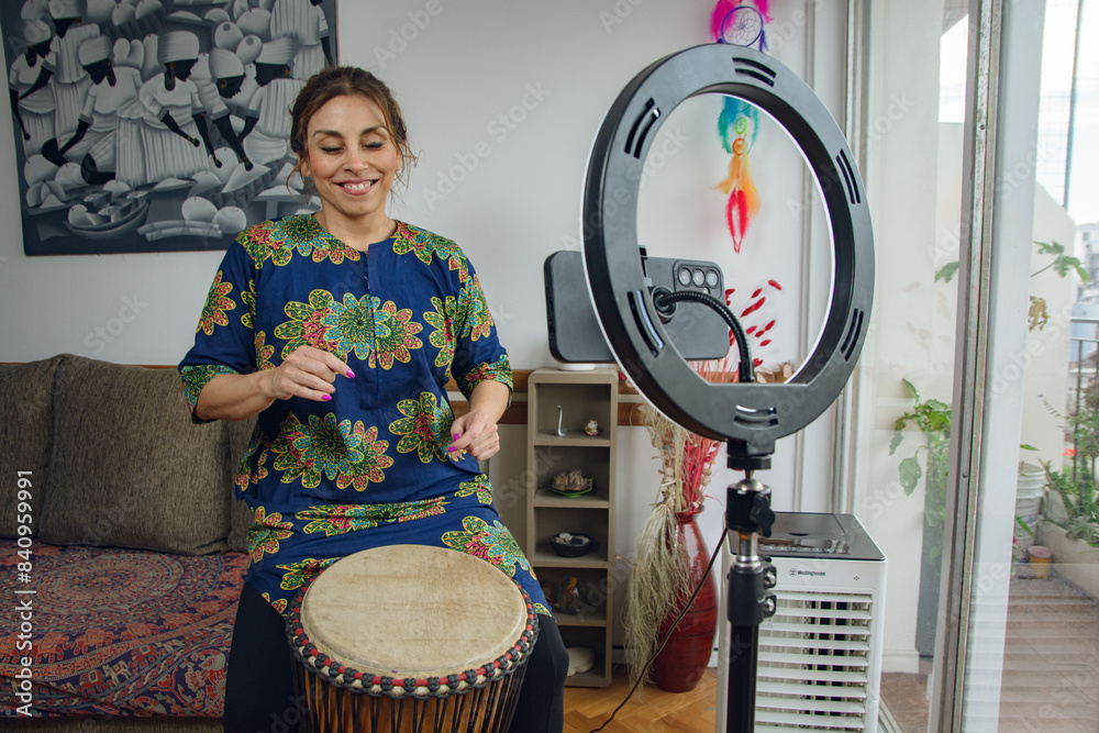 Fototapeta premium Happy Woman doing a live on the phone at home playing her drum