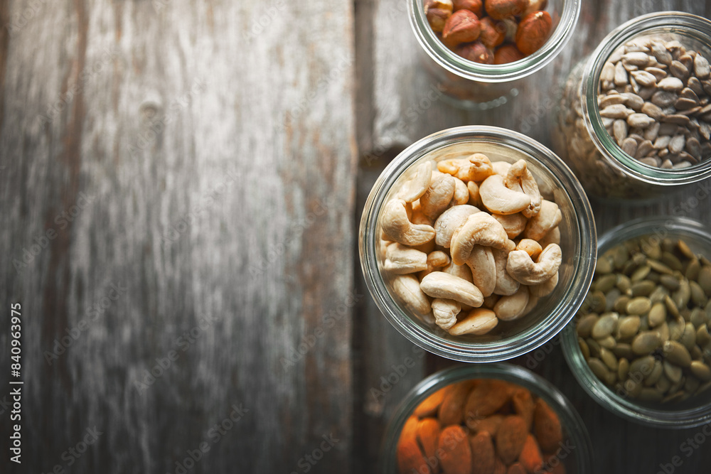 Bowls, cashew and nuts on table, above and mock up space for nutrition, health and promotion for wellness. Almond, hazelnut and pumpkin seeds in glass container for meal prep with food at apartment Bowls, cashew and nuts on table, above and mock up space for nutrition, health and promotion for wellness. Almond, hazelnut and pumpkin seeds in glass container for meal prep with food at apartment