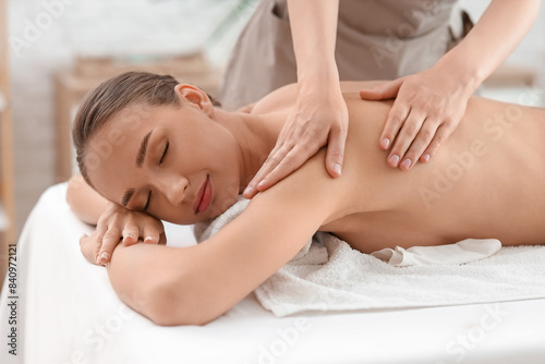 Beautiful young woman getting shoulder massage in spa salon  closeup