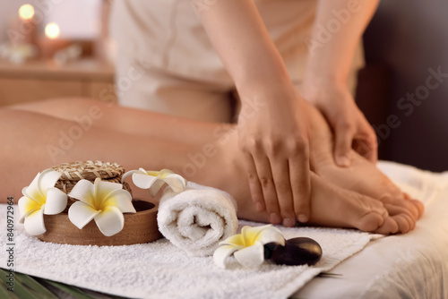 Young woman getting foot massage in dark spa salon  closeup