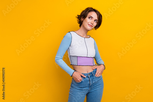 Photo of cute dreamy woman wear top looking empty space smiling isolated yellow color background
