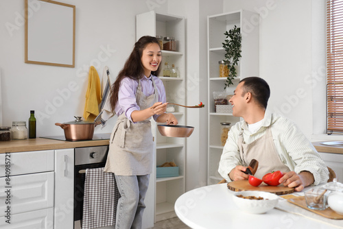 Young couple tasting soup i...