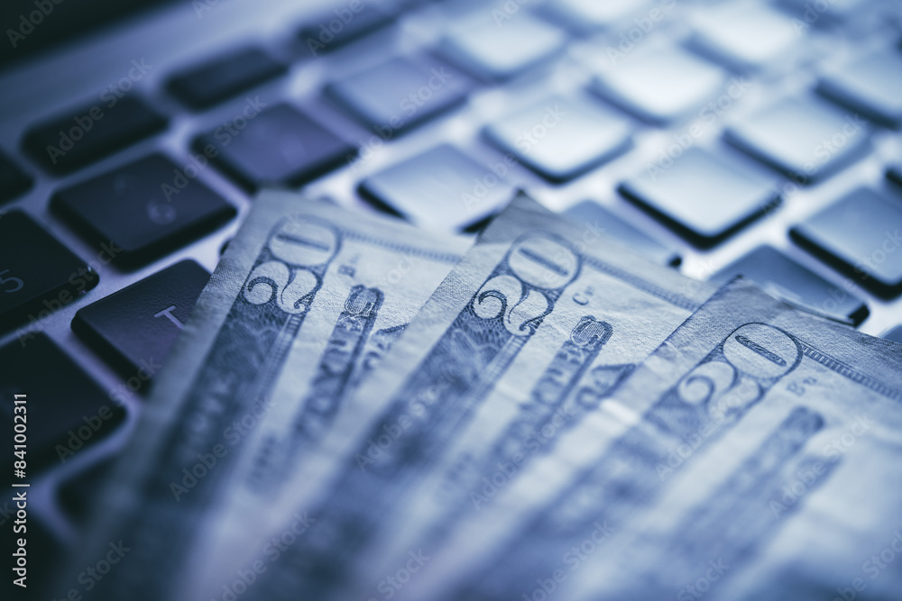 Close-up View of American Currency Partially Spread on a Laptop Keyboard Illustrating E-commerce or Online Trading Concepts Close-up View of American Currency Partially Spread on a Laptop Keyboard Illustrating E-commerce or Online Trading Concepts
