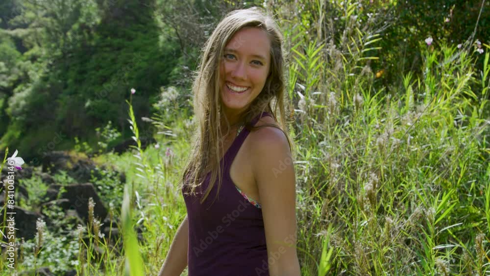 Woman smiling at camera in tall grass - medium, steady cam shot Woman smiling at camera in tall grass - medium, steady cam shot