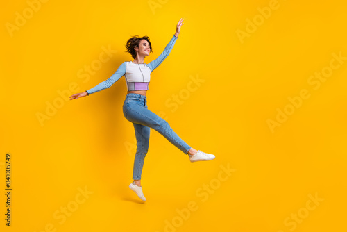 Full body photo of lovely cheerful lady jump rejoice good mood empty space isolated on yellow color background