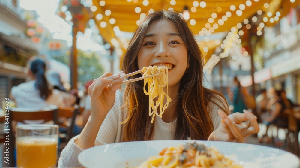 A woman is eating noodles with chopsticks in a restaurant A woman is eating noodles with chopsticks in a restaurant