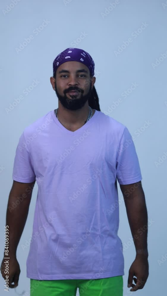 afro caribbean cuban man with beard and dreadlocks happy smiling in purple t shirt holding a dental aligners in isolated white background afro caribbean cuban man with beard and dreadlocks happy smiling in purple t shirt holding a dental aligners in isolated white background