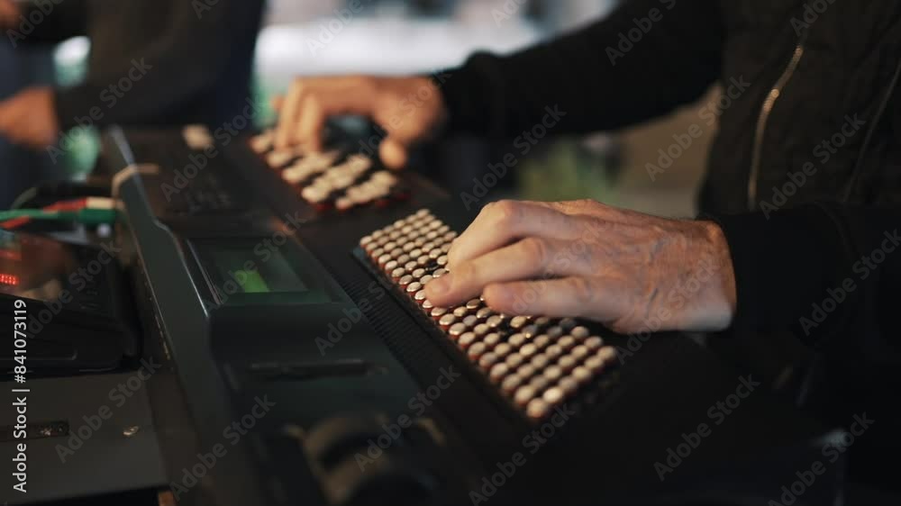 Closeup of hands playing a unique electronic keyboard with grid-like buttons. Closeup of hands playing a unique electronic keyboard with grid-like buttons.
