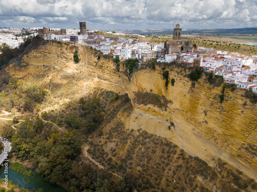 View of Arcos de la Frontera, medieval Andalusian town on towering vertical cliff on spring day, Spain photo