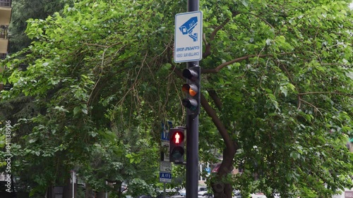 City traffic light on a rainy day going from green to red with a green tree at the end of spring start of summer 
in Tbilisi Georiga vake street photo