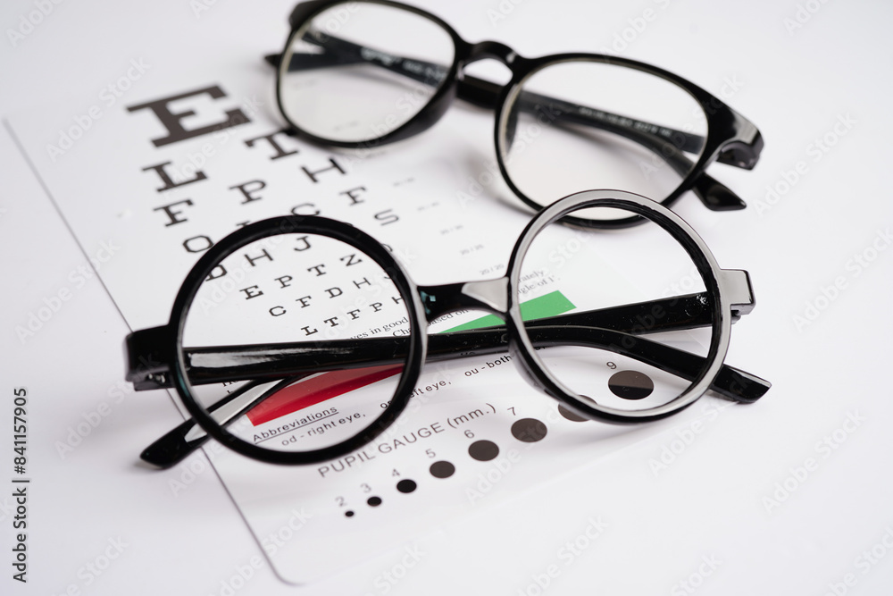 Glasses on eye exam chart to test eyesight accuracy of reading. Glasses on eye exam chart to test eyesight accuracy of reading.