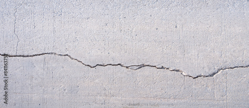Broken crack line texture background on the old damaged concrete street surface, directly above and panoramic view photo