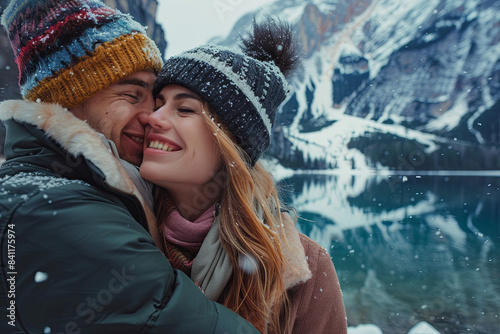 Romantic couple visiting alpine lake in Braies, Italy during winter