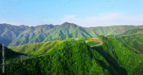 Aerial view of curvy highway road and green mountain nature landscape in Ningbo, China. Asphalt road on top of mountain.