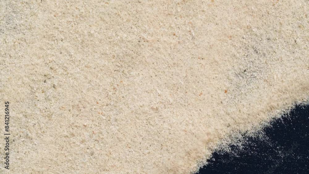Closeup of sand transition blowing over black abstract background in slow motion