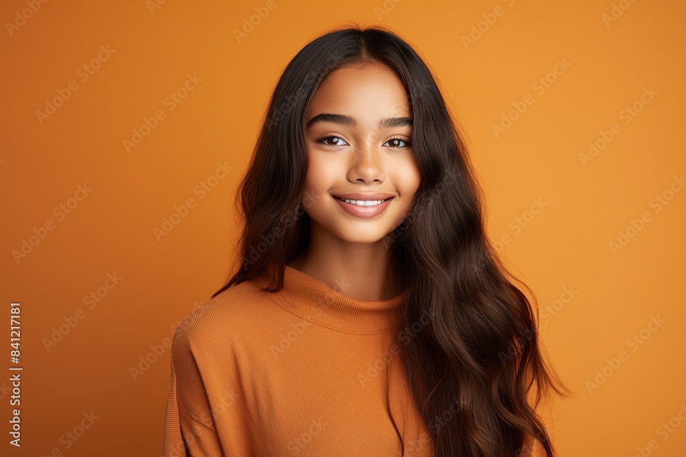 A young woman with long hair is smiling at the camera A young woman with long hair is smiling at the camera