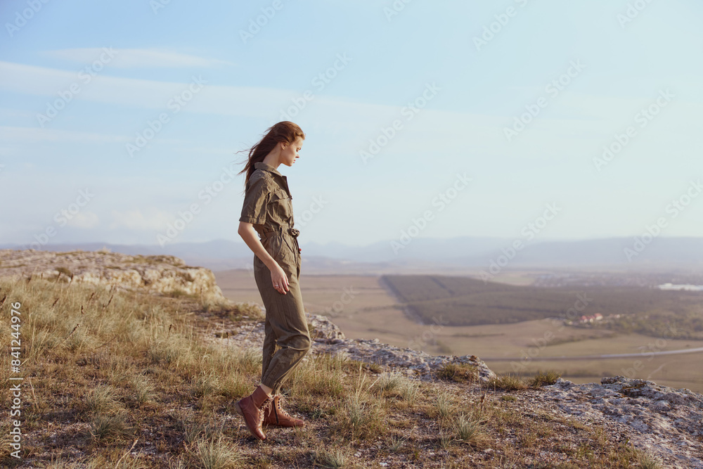 Woman standing on top of hill with view of valley below enjoying nature and travel beauty