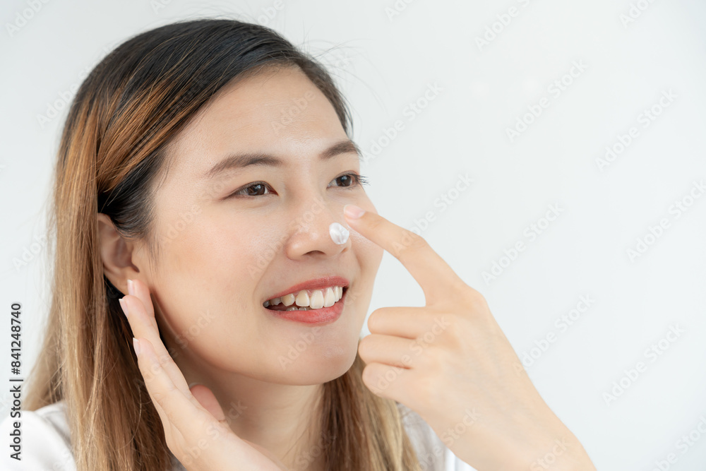 Beautiful Asian woman smile use cream touch on nose skin. face of a healthy woman apply cream and makeup. Advertisement for skin cream, anti-wrinkle, baby face, whitening, moisturizer, tighten pores Beautiful Asian woman smile use cream touch on nose skin. face of a healthy woman apply cream and makeup. Advertisement for skin cream, anti-wrinkle, baby face, whitening, moisturizer, tighten pores