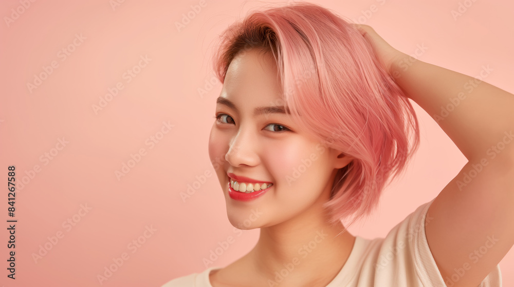 Young Asian woman with pink hair smiling against pink background. Young Asian woman with pink hair smiling against pink background.