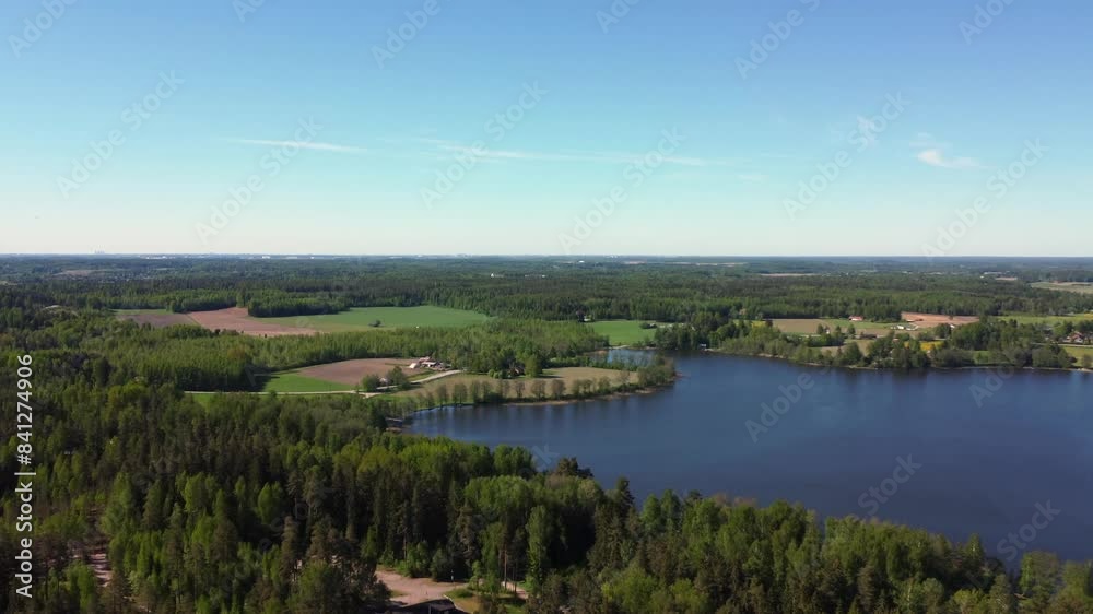 Vibrant northern landscape: Green forest, blue lake, blue sky horizon Vibrant northern landscape: Green forest, blue lake, blue sky horizon