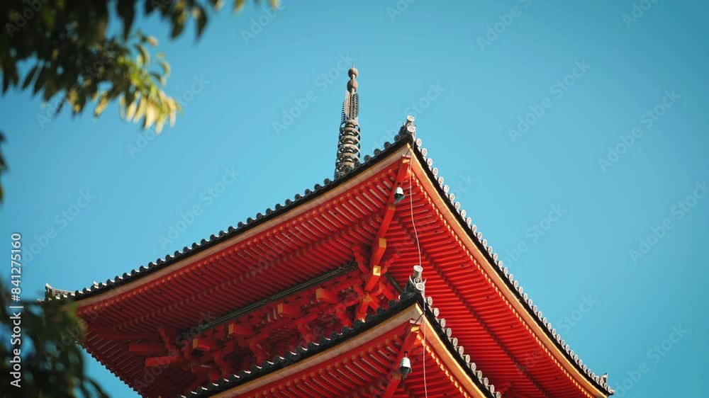 Vibrant red roof of the Kiyomizu-dera Temple pagoda, emphasizing its detailed craftsmanship against a clear blue sky. The architecture exemplifies traditional Japanese design and elegance Vibrant red roof of the Kiyomizu-dera Temple pagoda, emphasizing its detailed craftsmanship against a clear blue sky. The architecture exemplifies traditional Japanese design and elegance