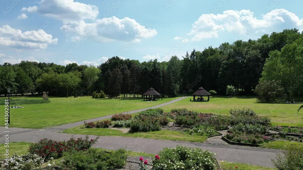 Bowers in park during a beautiful summer day surrounded by lush greenery, grass, flowers and trees under a clear blue sky Bowers in park during a beautiful summer day surrounded by lush greenery, grass, flowers and trees under a clear blue sky