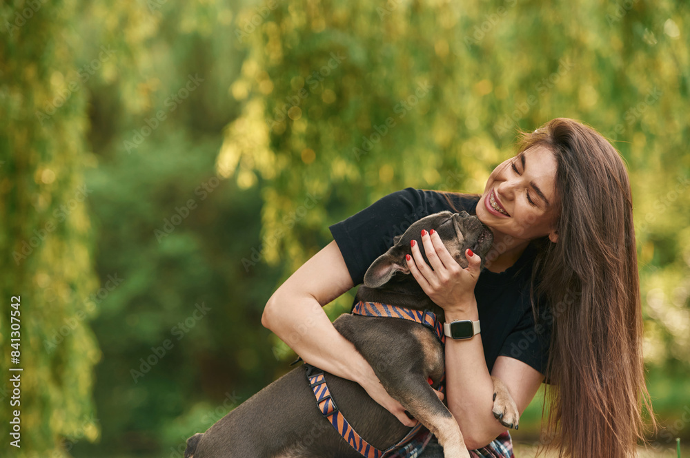 Embracing the animal. Young pretty woman is with her dog in the park Embracing the animal. Young pretty woman is with her dog in the park