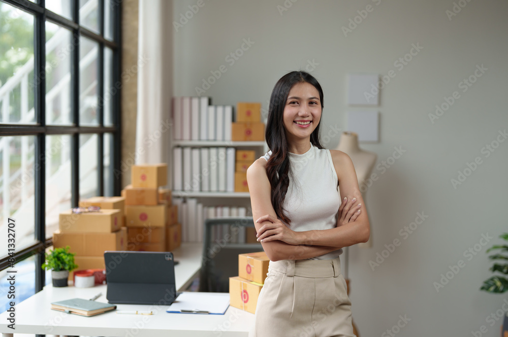 Independent business woman Asian freelance female employee smiling brightly Standing with arms crossed confidently, happy standing in the office, working online. Parcel shipping.