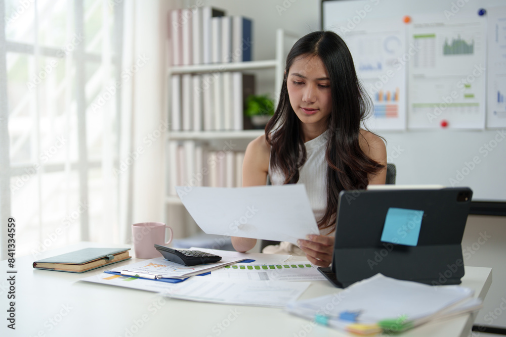 Confident businesswoman working with laptop and documents in home office, thinking, analyzing work happily.