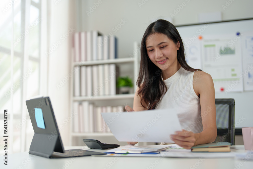 Confident businesswoman working with laptop and documents in home office, thinking, analyzing work happily.