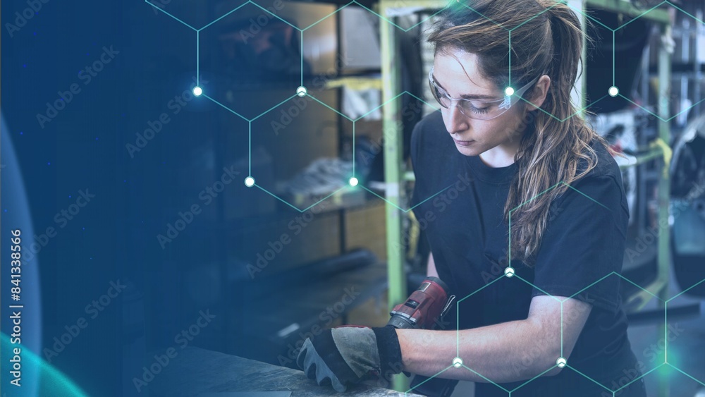 Naklejka premium Female mechanic drilling into metal