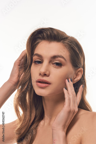 Wallpaper Mural A young woman with long wavy hair gently touches her face. Torontodigital.ca