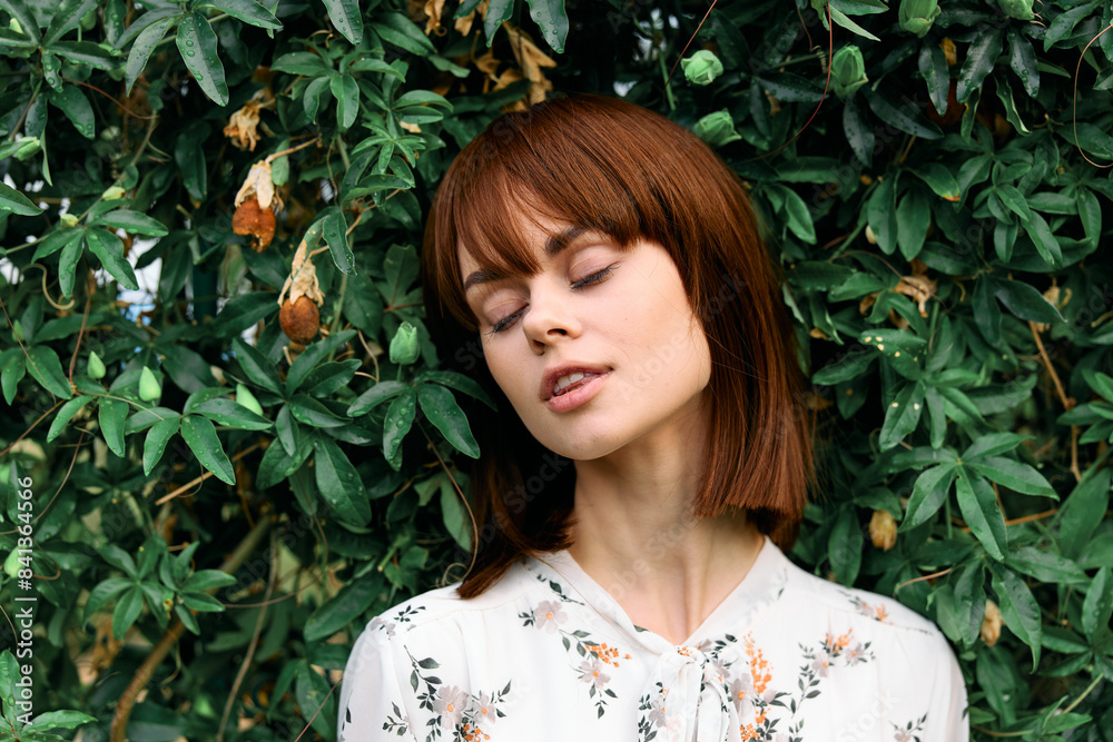 Tranquil woman standing by lush green bush with eyes closed in peaceful meditation Tranquil woman standing by lush green bush with eyes closed in peaceful meditation