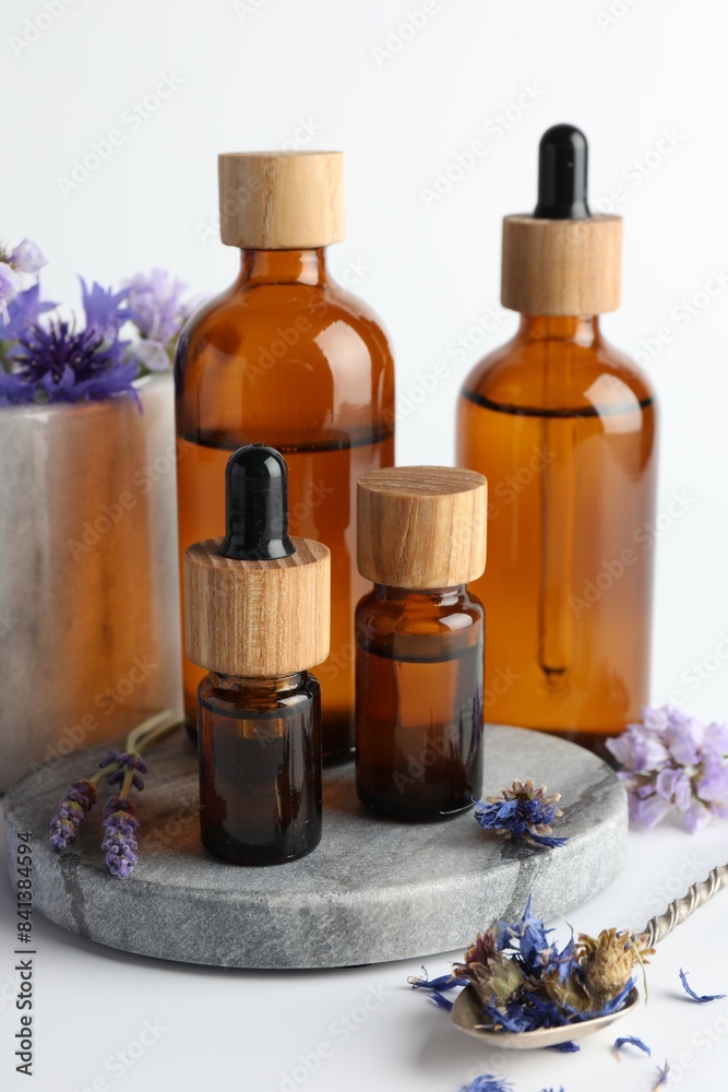 Aromatherapy. Different essential oils and flowers on white background Aromatherapy. Different essential oils and flowers on white background