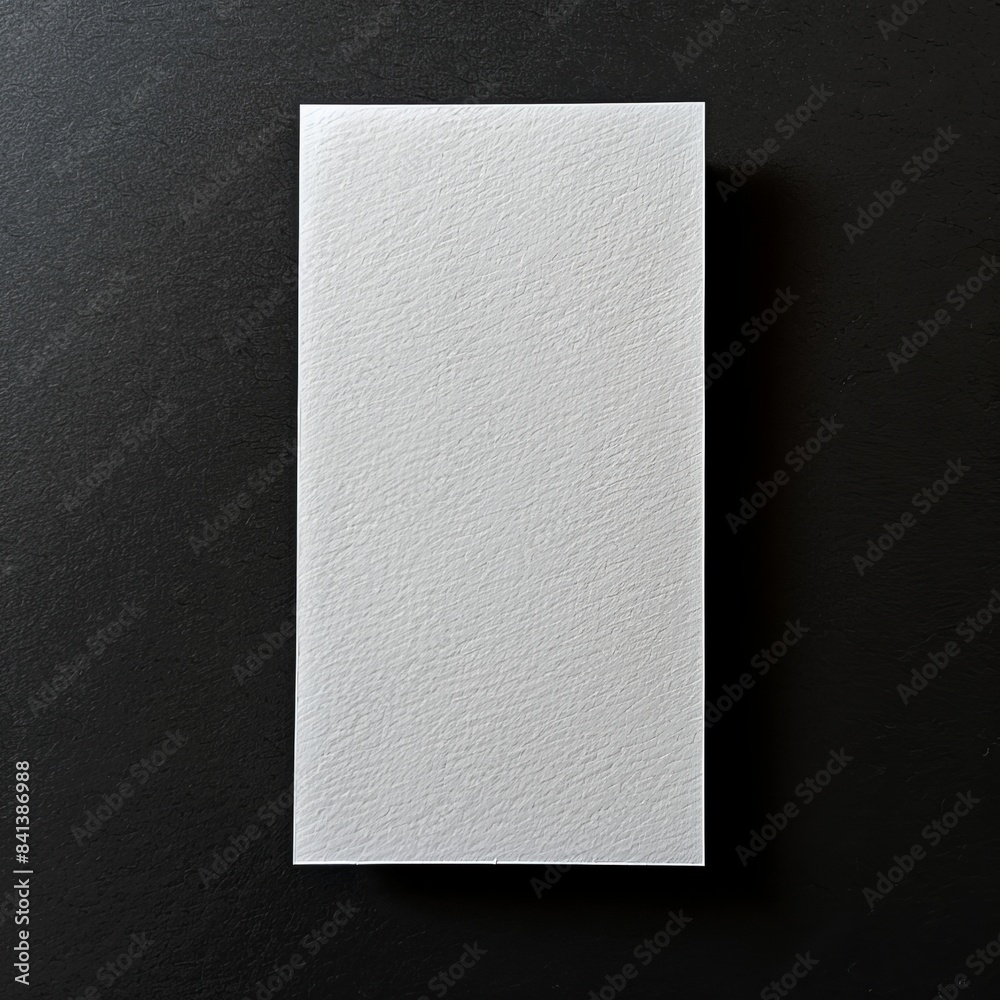 A single, white, rectangular piece of paper rests on a black background, ready to be filled with words, drawings, or ideas A single, white, rectangular piece of paper rests on a black background, ready to be filled with words, drawings, or ideas