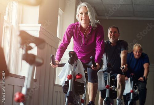 Fitness, spinning class and senior people in gym for cycling, exercise and training with physical activity. Workout club, men and woman on bicycle for health, wellness and endurance with cardio
