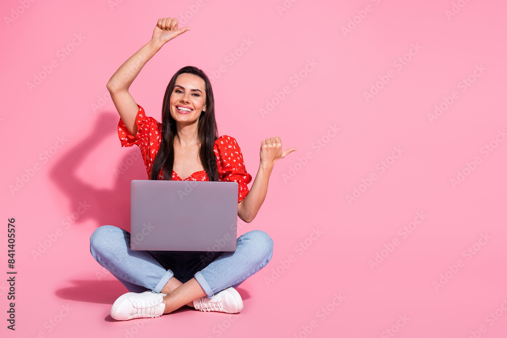 Full body portrait of nice young lady sit floor laptop point fingers empty space wear top isolated on pink color background Full body portrait of nice young lady sit floor laptop point fingers empty space wear top isolated on pink color background