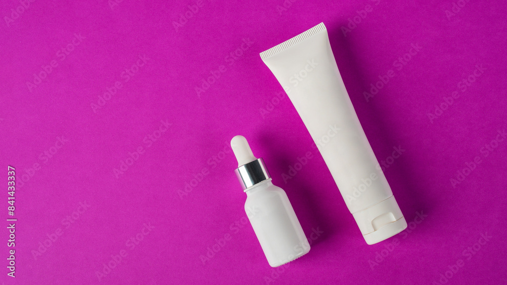 Plastic white tube for cream or lotion. Skin care or sunscreen cosmetic with stylish props on purple background Plastic white tube for cream or lotion. Skin care or sunscreen cosmetic with stylish props on purple background